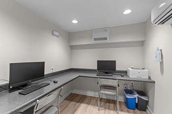 A room with a desk, computer, and monitor.